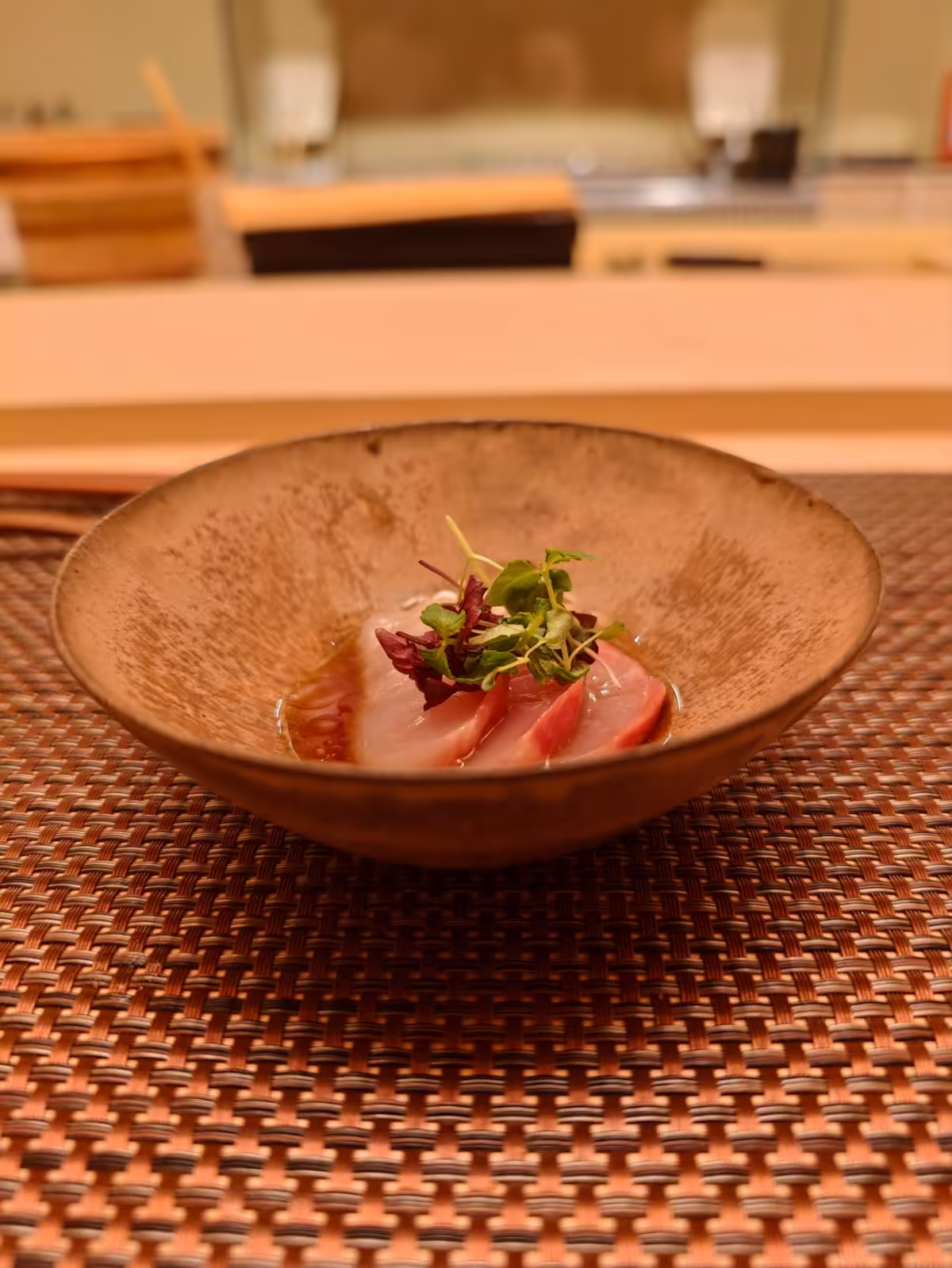 Sashimi in a ceramic bowl with herbs