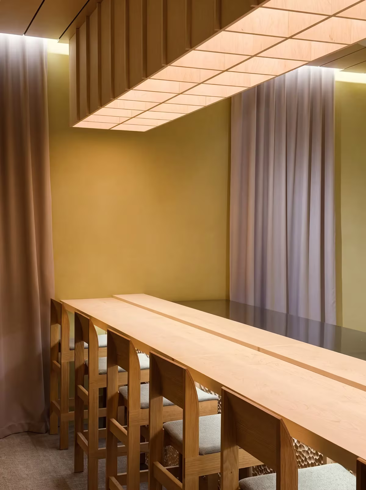 The counter and stools beneath the paper light at Hos Bobby